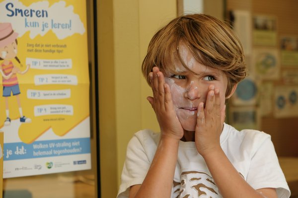 De kinderen smeren volop met de zonnebrandcrme